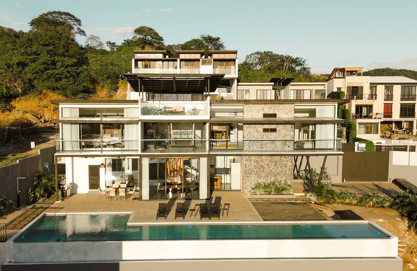 25-yard infinity pool with loungers and the lit facade at sunset